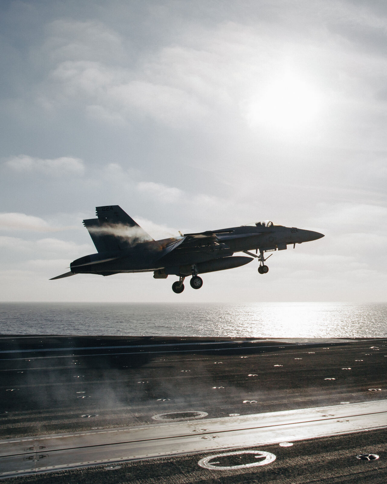 A jet launching off a carrier deck into the sun