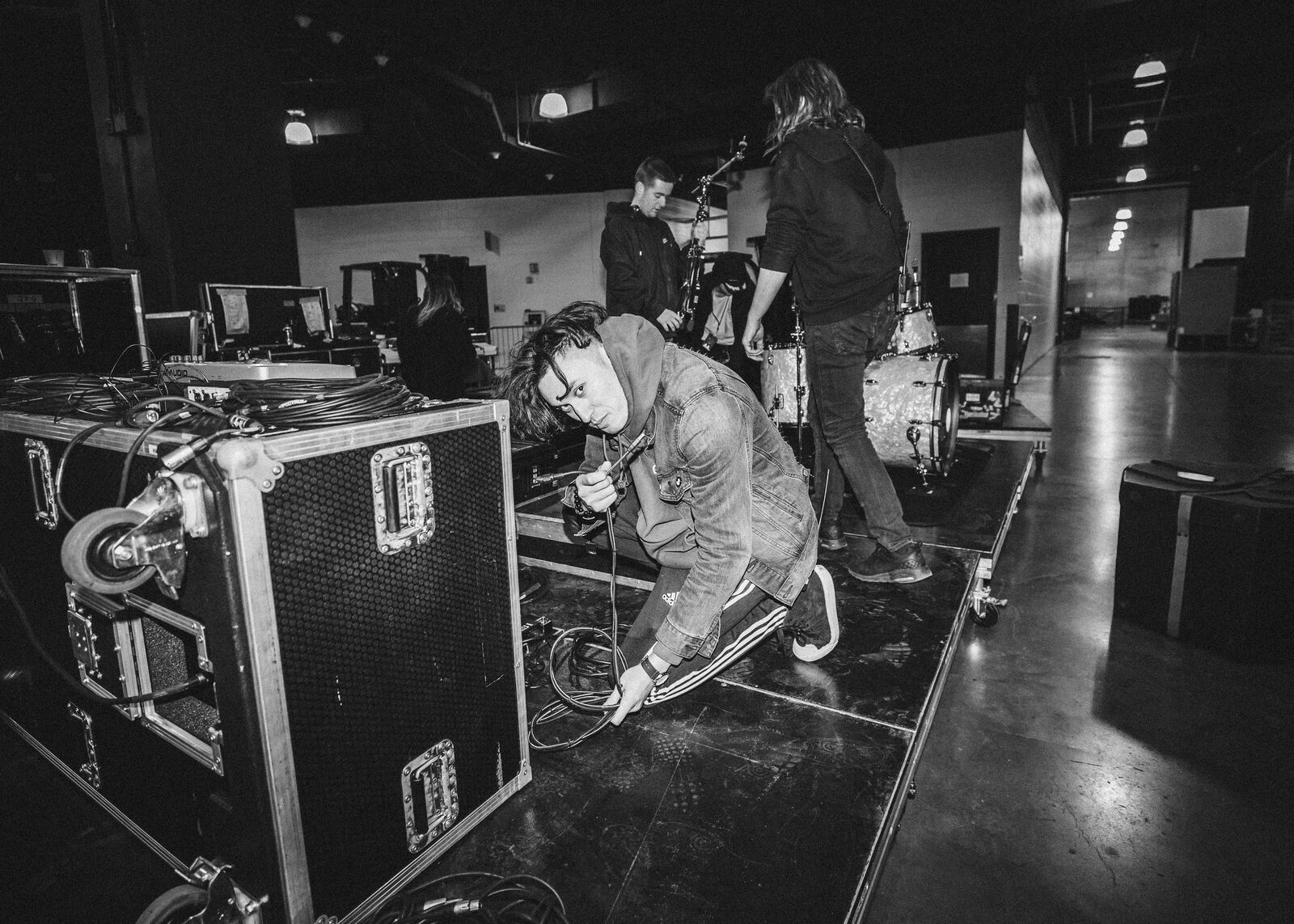 Black-and-white crew loading a road case