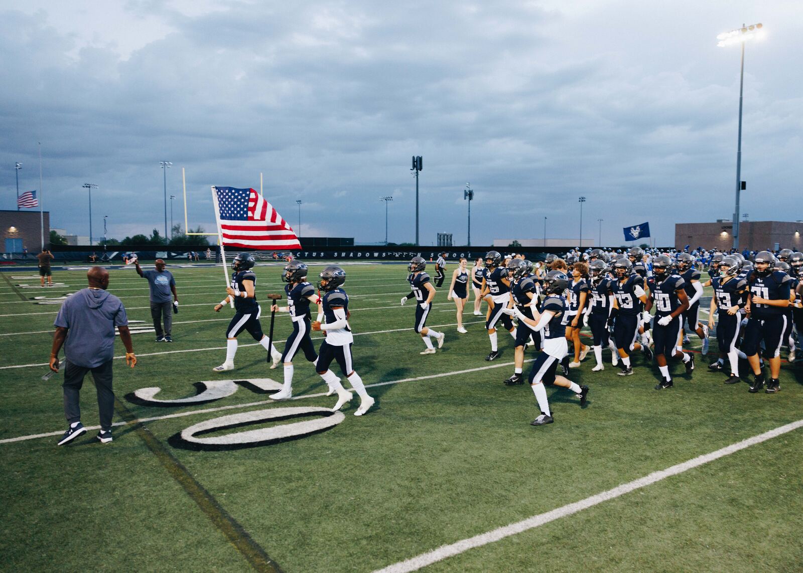 Football team running out behind the flag