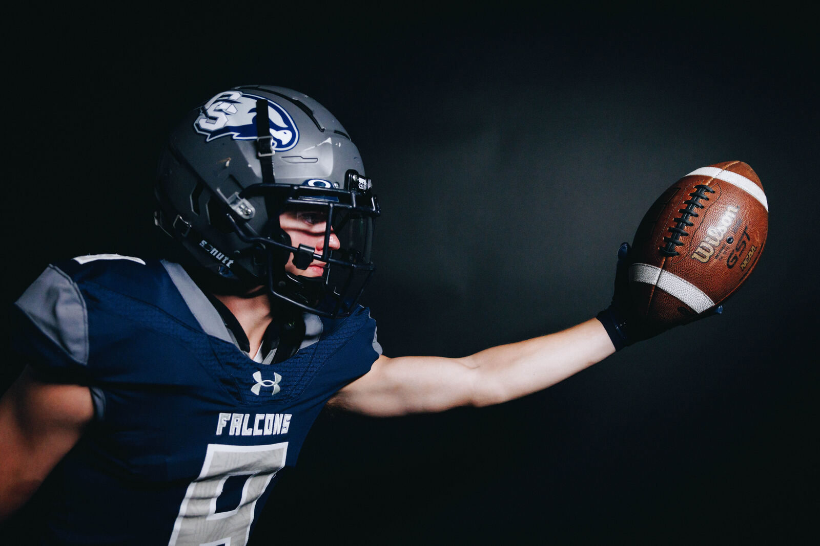 Football player reaching with the ball